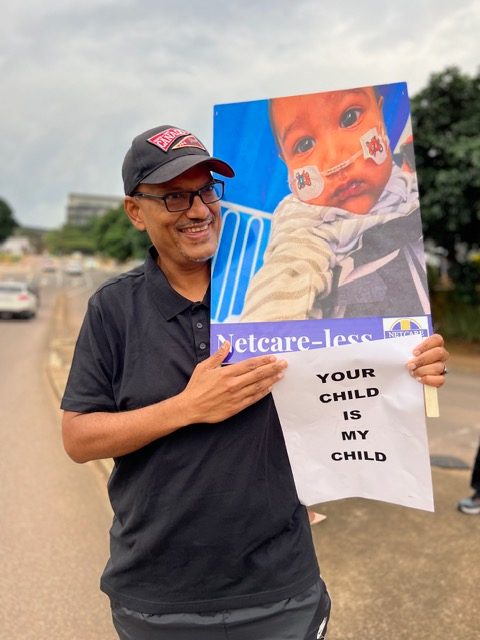 'Netcare-less' placard with baby photo