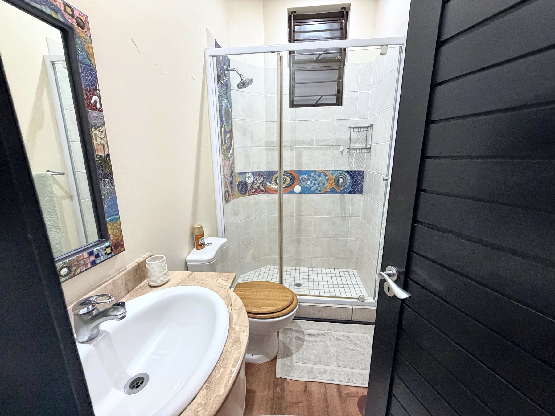 Guest bathroom with shower and mosaic tiling